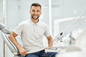 Smiling dental patient sitting upright in treatment chair