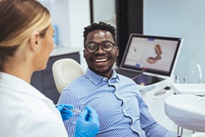 Smiling man interacting with dental team member