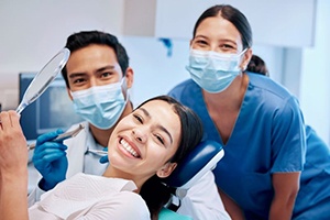 Happy patient posing with dental team