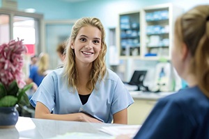 Dental team member talking to patient at front desk