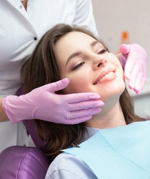 patient smiling while looking in dental mirror